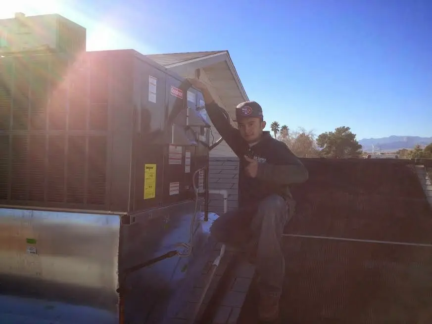 HVAC technician performing AC Tune-Up on a rooftop unit in Council Bluffs